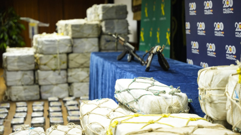 Fardos de droga y dos kalashnikov incautados por la Policía y la Guardia Civil.