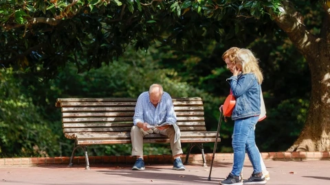 Un senior en el parque ante la mirada de dos mujeres