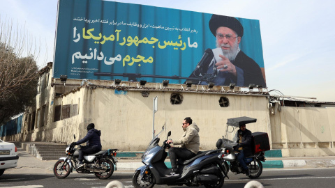 Iraníes pasan frente a una valla publicitaria con un mensaje contra Donald Trump en una calle de Teherán.