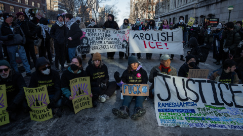 Personas sostienen pancartas mientras bloquean una calle en un acto de desobediencia civil frente a la Universidad de Columbia durante una protesta contra el ICE en Nueva York, Estados Unidos
