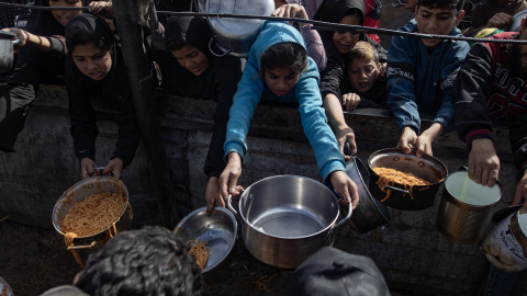 Palestinos desplazados en Khan Yunis Palestinos desplazados, incluidos niños, reciben alimentos de un comedor benéfico en Khan Yunis.