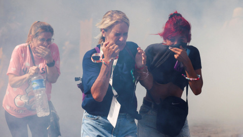 Varias mujeres corren entre los gases lacrimógenos de la policía, en los enfrentamientos por la reforma laboral de Milei. Varias mujeres corren entre los gases lacrimógenos de la policía, en los enfrentamientos por la reforma laboral de Milei.