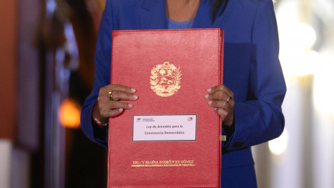 La presidenta encargada de Venezuela, Delcy Rodríguez, sostiene el documento de la aprobada ley de amnistía este jueves.