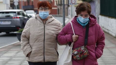 Dos mujeres con mascarilla caminan este viernes por unas calles prácticamente vacías en Muskiz, Bizkaia, este viernes 27 de febrero.