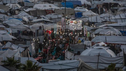 GAZA CITY (---), 06/03/2026.- Palestinos desplazados se reúnen entre tiendas de campaña improvisadas para romper el ayuno con una comida iftar juntos durante el mes sagrado de ayuno de Ramadán en el oeste de Gaza, el 6 de marzo de 2026. Los musulmanes de todo el mundo celebran el Ramadán rezando durante la noche y absteniéndose de comer, beber y tener relaciones sexuales durante el período entre el amanecer y el atardecer. EFE/MOHAMMED SABER