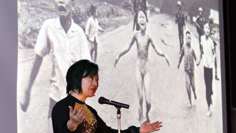 La vietnamita-canadiense Phan Thi Kim Phuc en una charla en Japón en 2013. Tras ella se proyecta la fotografía que protagonizó con 9 años, cuando ella y otros niños fueron alcanzados por una bomba de napalm lanzada por el Ejército del Sur de Vietnam