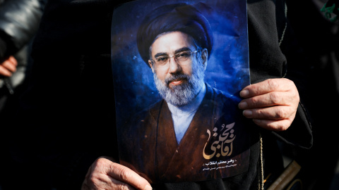 Una manifestante iraní muestra una fotografía del nuevo líder supremo iraní, Mojtaba Jamenei.