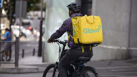 Imagen de archivo de un repartidor de Glovo en bicicleta por una calle de Madrid. Imagen de archivo de un repartidor de Glovo en bicicleta por una calle de Madrid.