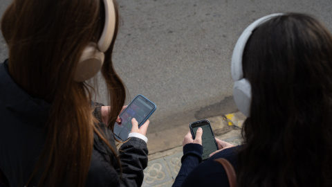 Dos personas usando el teléfono móvil. Dos personas usando el teléfono móvil.