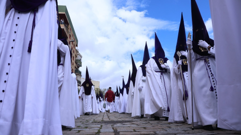 Los nazarenos de la Hermandad de San Benito saliendo del templo tras la suspensión de la Estación de Penitencia por la lluvia, en la Semana Santa de Sevilla 2022.