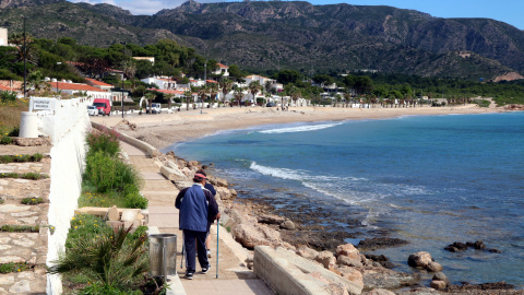 Pla general de dues persones que passegen en direcció a la platja de l'Almadrava, al municipi de Vandellòs i l'Hospitalet de l'Infant (Baix Camp), municipi no tensionat per l'habitatge