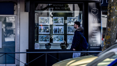 Un joven pasa delante de una agencia inmobiliaria en Madrid, en una imagen reciente,