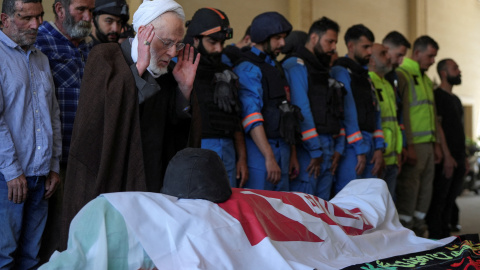 Hombres libaneses velan el cadáver de un asesinado en los bombardeos de Israel.