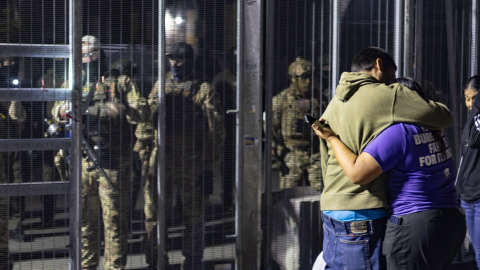 Un hombre frente al centro de detención de ICE en Broadview mientras agentes esperan para detenerlo.