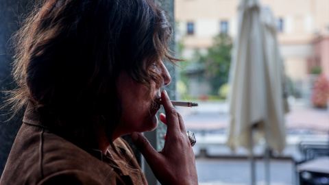 Una persona fumando en la calle en una foto de archivo. Una persona fumando en la calle en una foto de archivo.