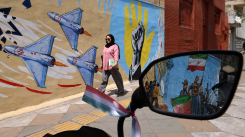Una mujer pasa junto a un mural antiestadounidense y antiisraelí en Teherán este 21 de abril de 2026.
