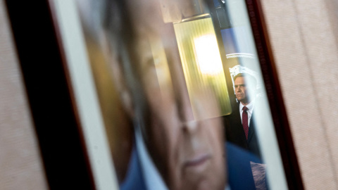 El fiscal general Todd Blanch reflejado en una fotografía del Presidente Donadls Trumo mientras se anuncia.