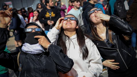 Varias personas miran arriba para observar un eclipse. Varias personas miran arriba para observar un eclipse.