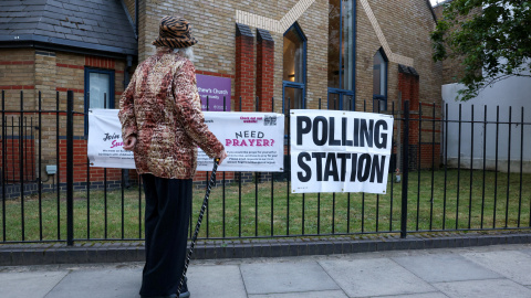 Centro de votación para las elecciones locales británicas Una mujer frente a un centro de votación para las elecciones locales británicas ubicado en una iglesia.