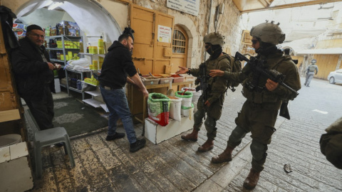 Soldados israelíes increpan al dueño de una tienda palestina en la ciudad de Hebrón, en la Cisjordania ocupada. Soldados israelíes increpan al dueño de una tienda palestina en la ciudad de Hebrón, en la Cisjordania ocupada.