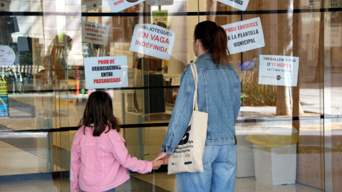 Dues usuàries davant la porta tancada de la biblioteca Montserrat Abelló, a les Corts Dues usuàries davant la porta tancada de la biblioteca Montserrat Abelló, a les Corts