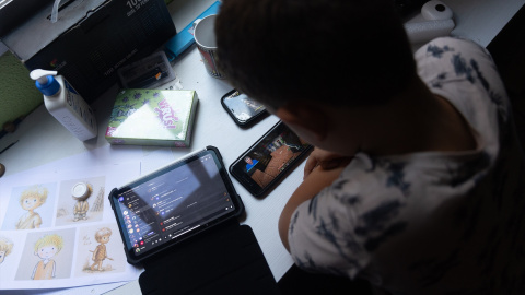 Foto de archivo de un niño usando el teléfono móvil y una tablet. Foto de archivo de un niño usando el teléfono móvil y una tablet.