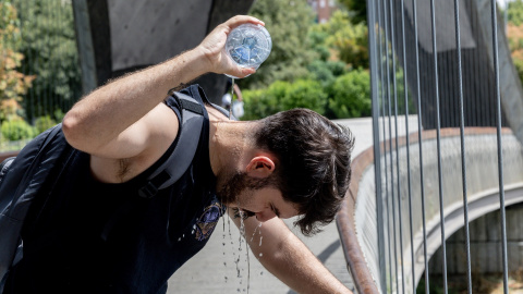 Un chico se moja la cabeza a causa del calor. Un chico se moja la cabeza a causa del calor.