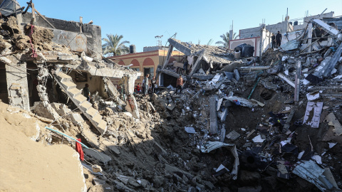 Varios palestinos inspeccionan los escombros de un edificio destruido por un ataque aéreo israelí.