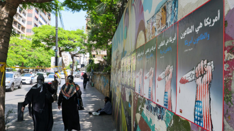Dos mujeres caminan junto a carteles con propaganda antiestadounidense este martes en Beirut (Líbano).