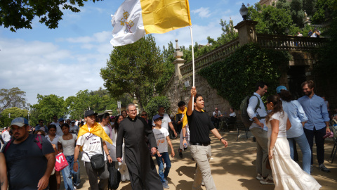 Un noi camina cap a l'Estadi Olímpic mentre oneja una bandera del Vaticà. Un noi camina cap a l'Estadi Olímpic mentre oneja una bandera del Vaticà.