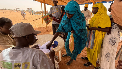Una mujer en el campo de refugiados de Aboutengue, Chad, recibiendo su ración de comida.