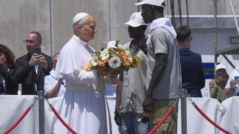 El papa León XIV recibe flores de dos voluntarios para protagonizar una ofrenda floral en el mar en recuerdo de los migrantes muertos en la travesía en el muelle de Arguineguín, en la isla de Gran Canaria, El papa León XIV recibe flores de dos voluntarios para protagonizar una ofrenda floral en el mar en recuerdo de los migrantes muertos en la travesía en el muelle de Arguineguín, en la isla de Gran Canaria.