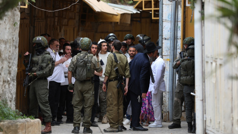 Colonos en la ciudad vieja de Hebrón bajo la protección del Ejército israelí. Colonos en la ciudad vieja de Hebrón bajo la protección del Ejército israelí.