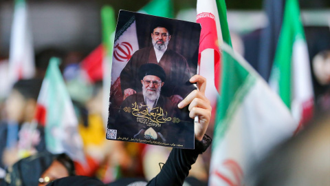 Una mujer iraní levanta un retrato del actual líder supremo, Ayatollah Mojtaba Khamenei, junto a su predecesor.
