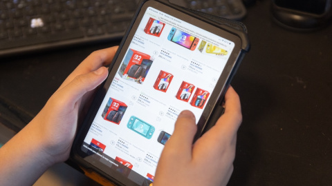 Una persona realiza una búsqueda en Aliexpress con su tablet. Una persona realiza una búsqueda en Aliexpress con su tablet.