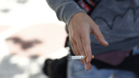 Una persona fumando un cigarrillo.