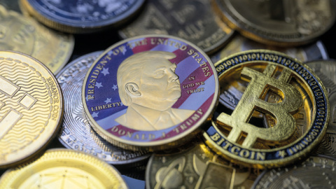 Una moneda Trump junto a un bitcoin y otras criptomonedas en Bruselas el 5 de agosto de 2025.