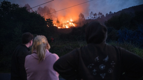 Varias personas asisten impotentes a un incendio forestal en el monte Galleiro, Pontevedra.