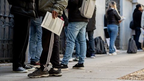 Varias personas hacen cola para solicitar los papeles necesarios para acogerse a la regularización.