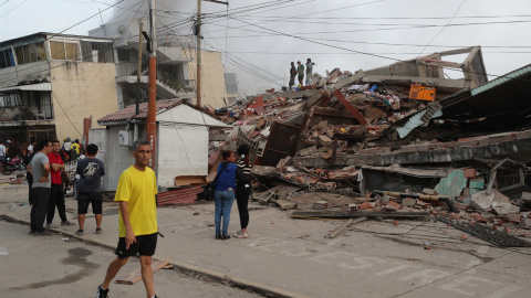 Residentes permanecen en la calle junto a varios bloques de viviendas dañados por los terremotos, en la localidad de Catia La Mar, en el estado costero de La Guaira (Venezuela) este jueves.