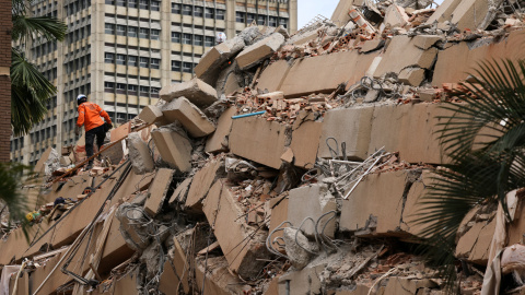 Una persona ayuda a remover escombros de edificios derrumbados por los terremotos en Caracas.