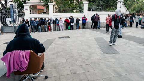 Varias personas hacen cola para conseguir el certificado de vulnerabilidad en una Oficina de Asistencia en Materia de Registro en Madrid.