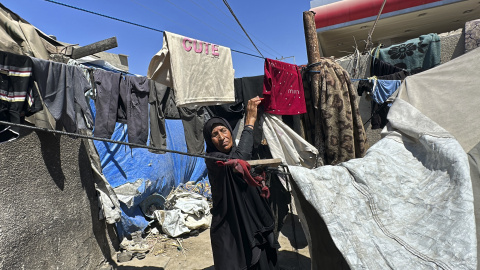 Munawar al Raai, mujer gazatí de 60 años, tiende la ropa en la tienda de campaña en la que vive Munawar al Raai, mujer gazatí de 60 años, tiende la ropa en la tienda de campaña en la que vive