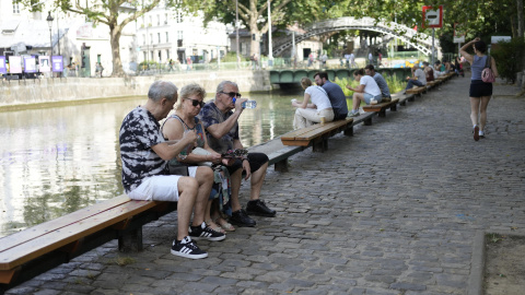 Varias personas descansan a orillas del Sena en París durante la ola de calor. Varias personas descansan a orillas del Sena en París durante la ola de calor.