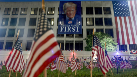 Banderas estadounidenses frente a una pancarta del presidente de EEUU Donald Trump en edificio del Departamento de Trabajo, en vísperas del 4 de julio.