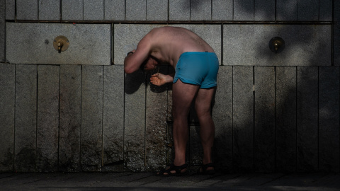 Imagen de archivo de una persona refrescándose en una fuente de Madrid. Imagen de archivo de una persona refrescándose en una fuente de Madrid.