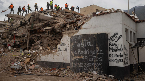 Personas realizan labores de búsqueda entre los escombros de edificios destruidos por terremotos este lunes, en La Guaira (Venezuela).