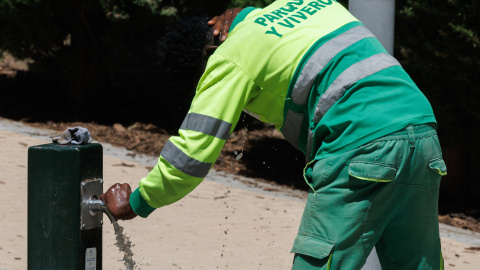 trabajador-calor Un trabajador coge agua en una fuente en el Parque del Manzanares.