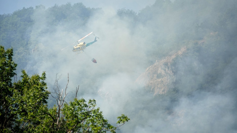 Un helicóptero ayuda en las labores para extinguir el incendio forestal en Ribota de Sajambre, León, Castilla y León (España).