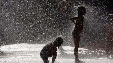 Dos niños se refrescan el pasado domimgo en un parque público de Fráncfort (Alemania). Dos niños se refrescan el pasado domimgo en un parque público de Fráncfort (Alemania).